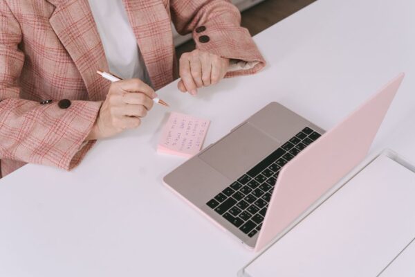 A small business owner using a laptop, with a magnifying glass icon hovering over text on the screen, symbolizing fact-checking AI output.
