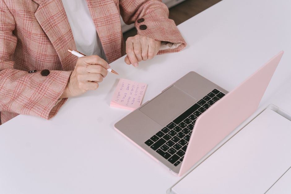 A small business owner using a laptop, with a magnifying glass icon hovering over text on the screen, symbolizing fact-checking AI output.