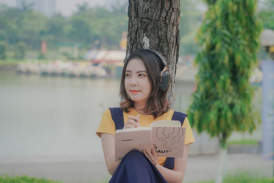 A person walking through a vibrant city park, listening to an audiobook with headphones, illustrating how audiobooks integrate into daily life.