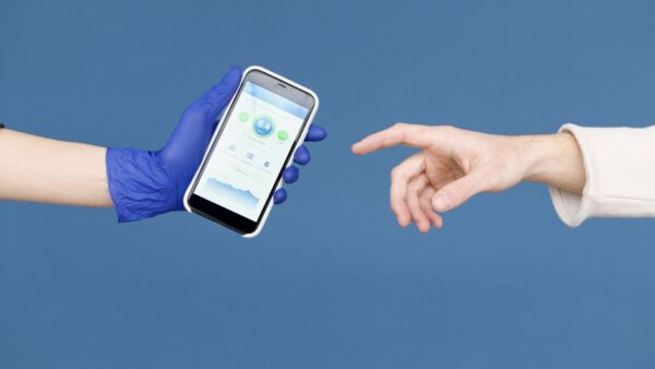 A person holding a smartphone, looking at a healthcare application interface displaying graphs and health metrics.