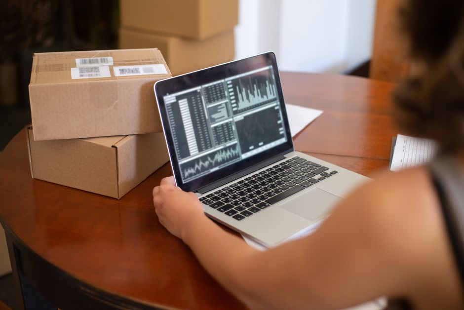 A person reviewing an e-commerce dashboard with graphs and data insights, highlighting how AI helps manage inventory and sales trends.