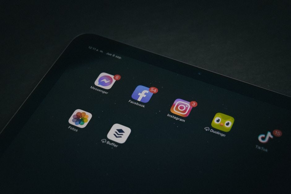 A person's hands using a tablet to organize and delete various app icons, symbolizing the management and optimization of digital subscriptions and services.