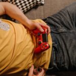 Person looking immersed while playing a story-driven video game on a console with a controller in their hands.