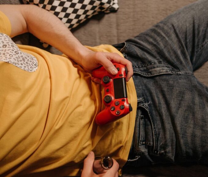 Person looking immersed while playing a story-driven video game on a console with a controller in their hands.