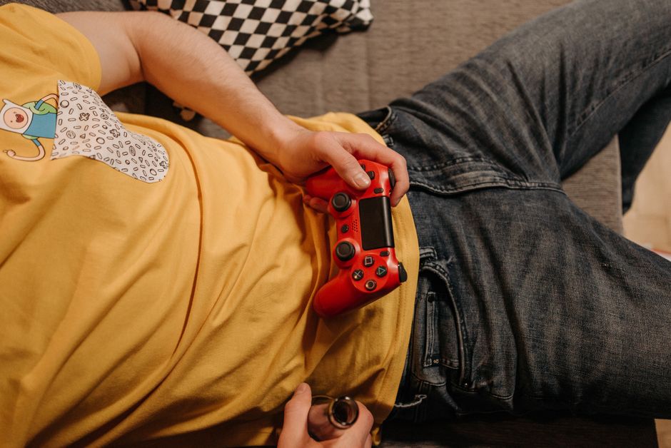 Person looking immersed while playing a story-driven video game on a console with a controller in their hands.