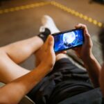 A person's hands holding a smartphone, engrossed in a colorful open world game, representing stress-free mobile gaming.