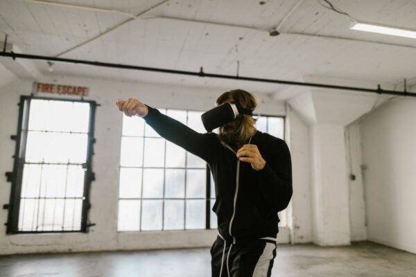 A person wearing a VR headset vigorously punching virtual targets in a fitness game, demonstrating an active workout.