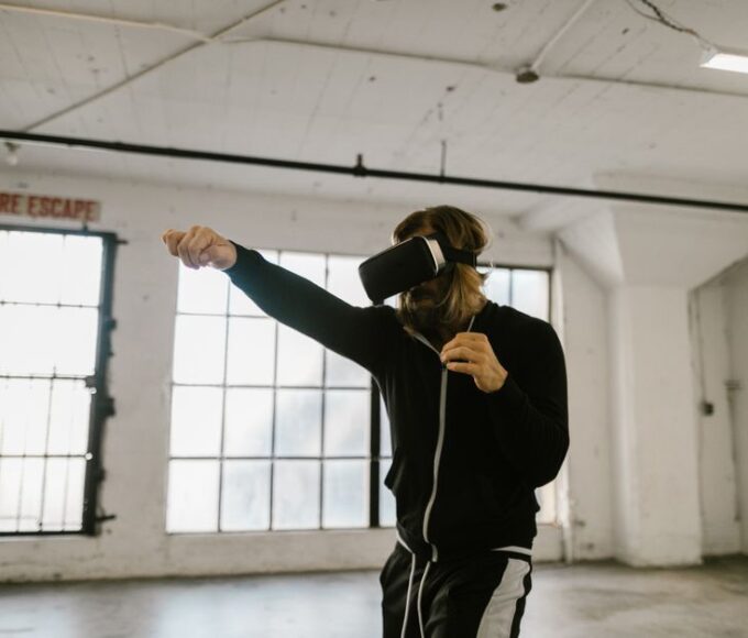 A person wearing a VR headset vigorously punching virtual targets in a fitness game, demonstrating an active workout.