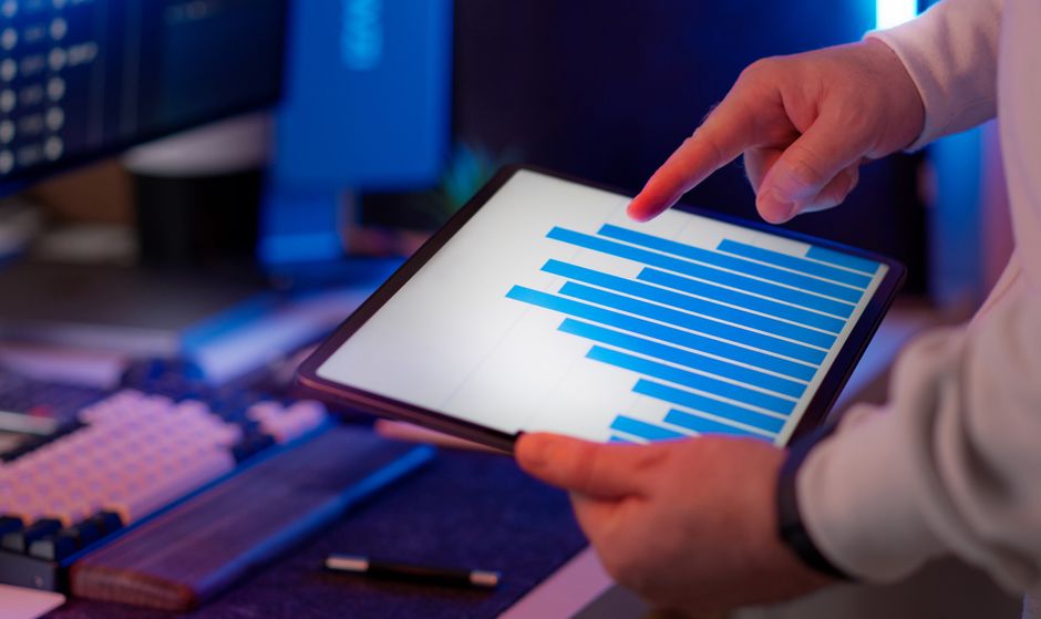 A person with thoughtful expression reviewing a detailed, complex report generated by AI on a tablet, surrounded by notes, highlighting the critical human judgment phase in decision-making.