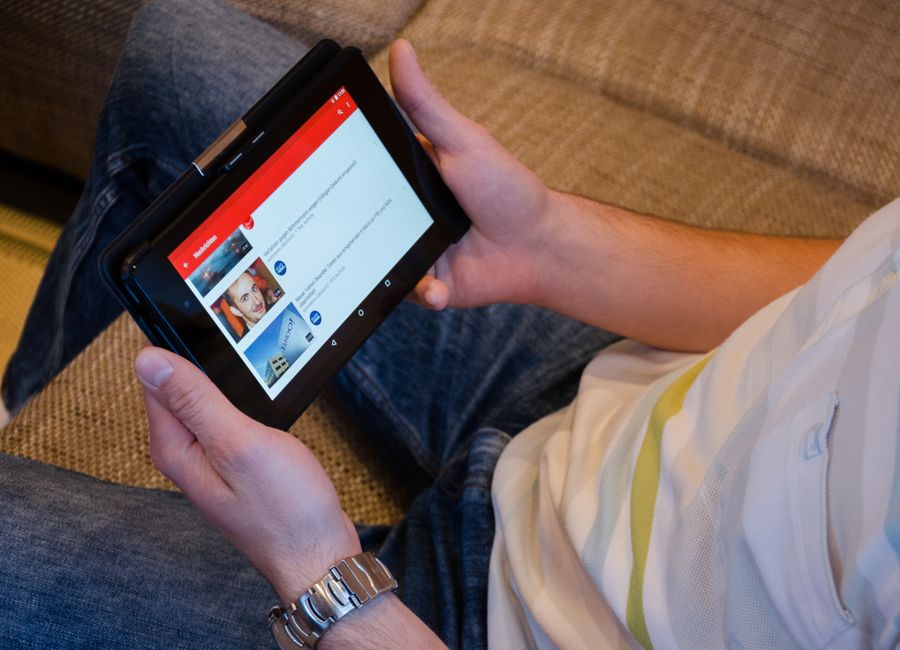 A young person on a couch confidently watching 4K content on a tablet, with smart home devices subtly visible in the background, illustrating seamless connectivity.