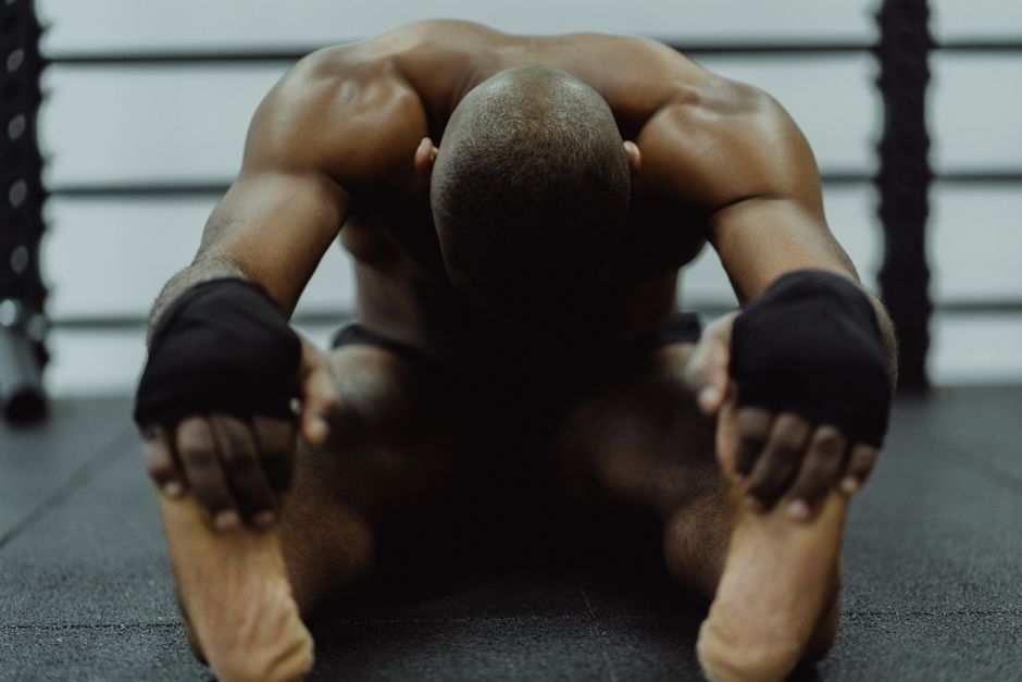 Person doing a post-workout cool-down stretch, emphasizing recovery after a strength training session.