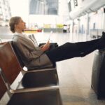 A person doing a gentle stretch in an airport lounge, highlighting flexible movement during travel.