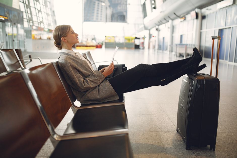 A person doing a gentle stretch in an airport lounge, highlighting flexible movement during travel.