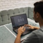 A person thoughtfully evaluating an AI tool's interface on a laptop screen, with a notebook for notes nearby, representing the trial process.