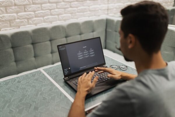A person thoughtfully evaluating an AI tool's interface on a laptop screen, with a notebook for notes nearby, representing the trial process.