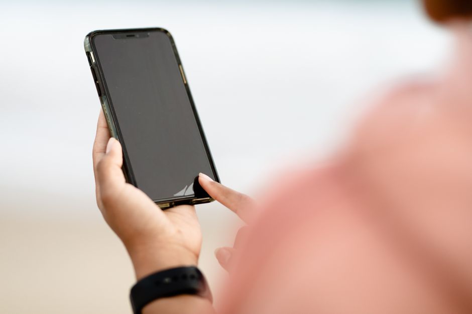 A person using a smartphone outdoors, typing a message with predictive text suggestions visible, showcasing everyday AI features in action.
