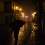 A person walking confidently through a sunny, humid city street, dressed in light, breathable fabrics.