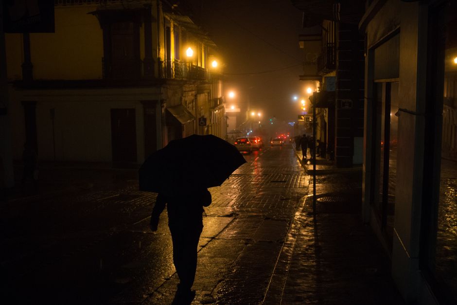A person walking confidently through a sunny, humid city street, dressed in light, breathable fabrics.