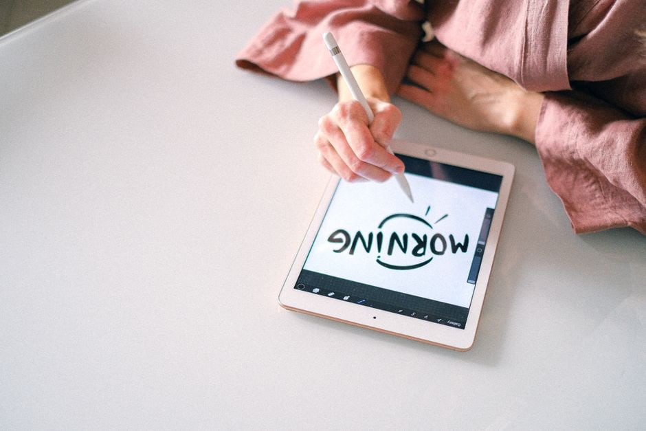 A person's hand holding a stylus, writing on a tablet screen with a note-taking app open, showing the ease of digital handwriting and annotation for capturing ideas.