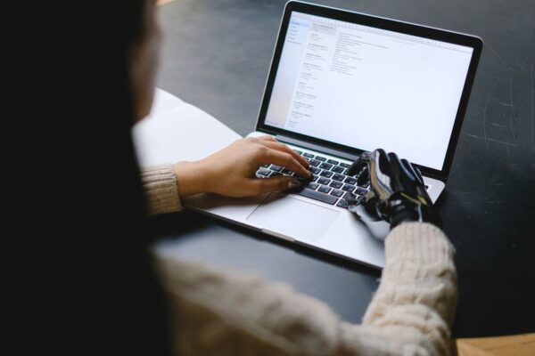 A person using a laptop with an AI assistant icon, symbolizing ethical interaction with AI tools in business.
