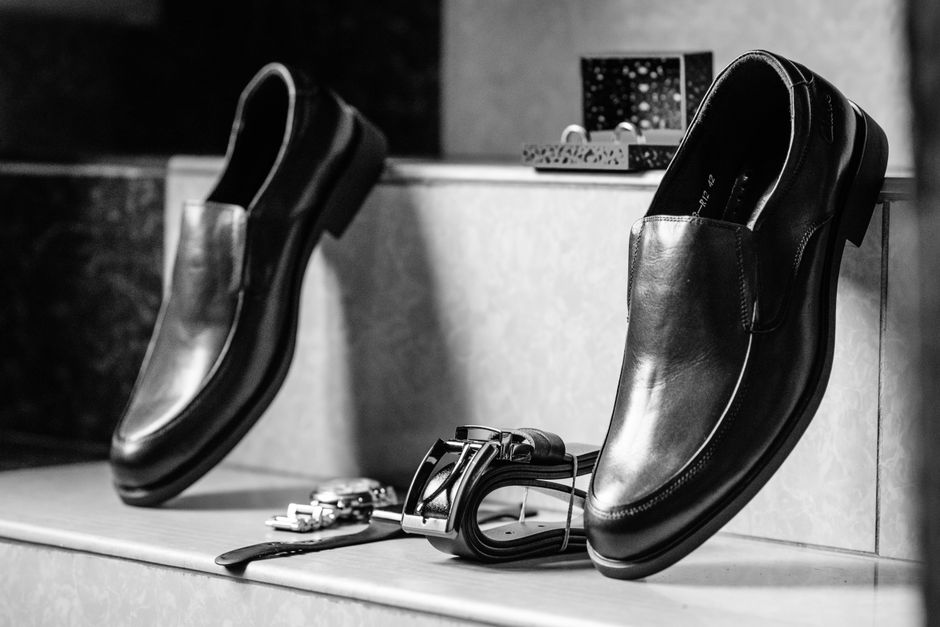 Close-up of classic leather loafers on a clean floor next to a structured, minimalist handbag, representing key accessories that elevate an affordable work outfit.