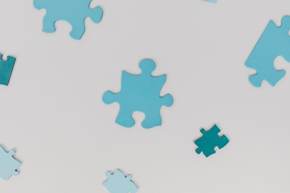 Abstract image of interconnected puzzle pieces, some brightly lit and some in shadow, symbolizing the complex and sometimes hidden patterns involved in detecting fake reviews and ensuring tech buying guide accuracy.