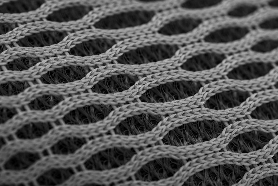 A close-up of a high-quality recycled nylon fabric swatch, showing its durable texture and subtle sheen, emphasizing material innovation.