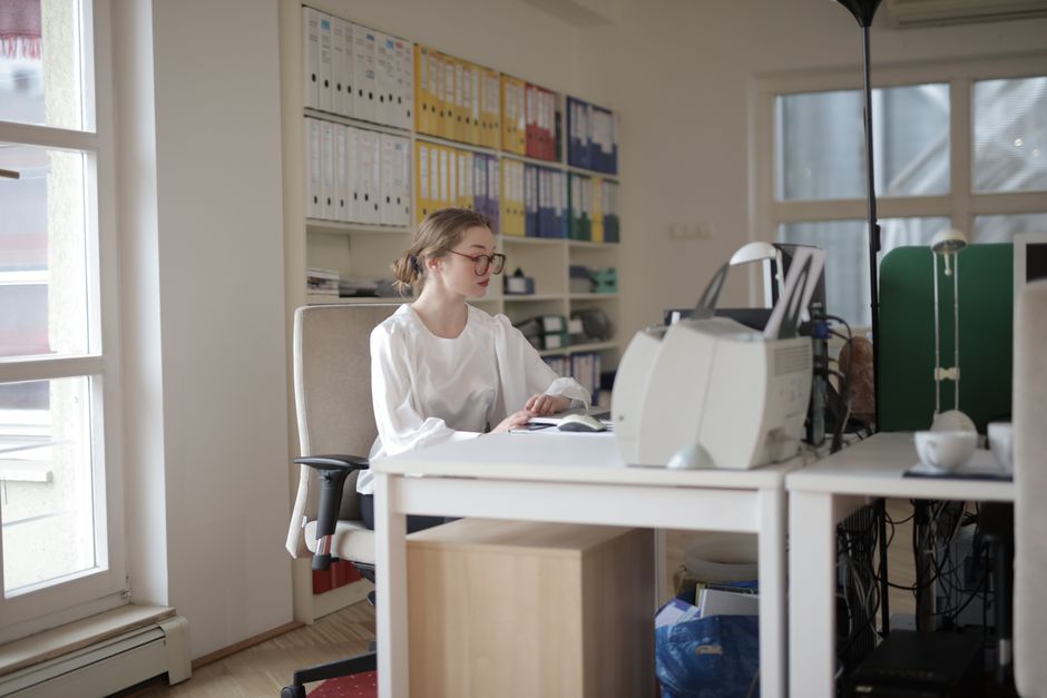 A neatly organized remote worker's desk with a laptop, external monitor, and a tidy workspace, symbolizing efficient digital management.