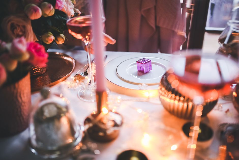 A close-up of a rustic wooden board laden with cheeses, crackers, and fruits, set up as a simple appetizer spread on a compact table in a small apartment.