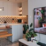 A clean, organized small living room with light furniture and smart storage.