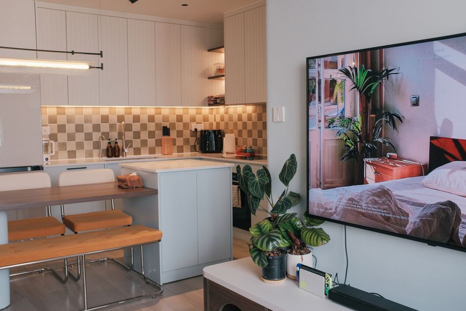 A clean, organized small living room with light furniture and smart storage.