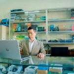 A small business owner meticulously inspecting the screen and keyboard of a refurbished laptop, making sure it meets quality standards.