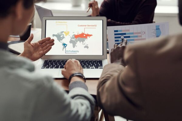 A small business owner using a laptop with a global map overlay, planning international business trips, symbolizing AI for trip planning.