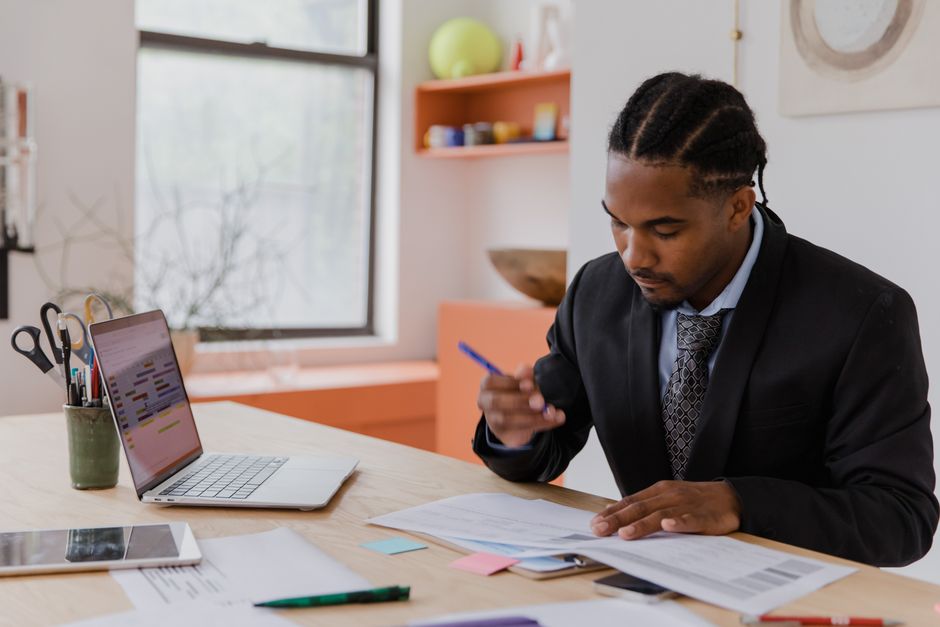 A small business owner focused on a laptop screen, reviewing digital financial documents and receipts, demonstrating efficient file management.