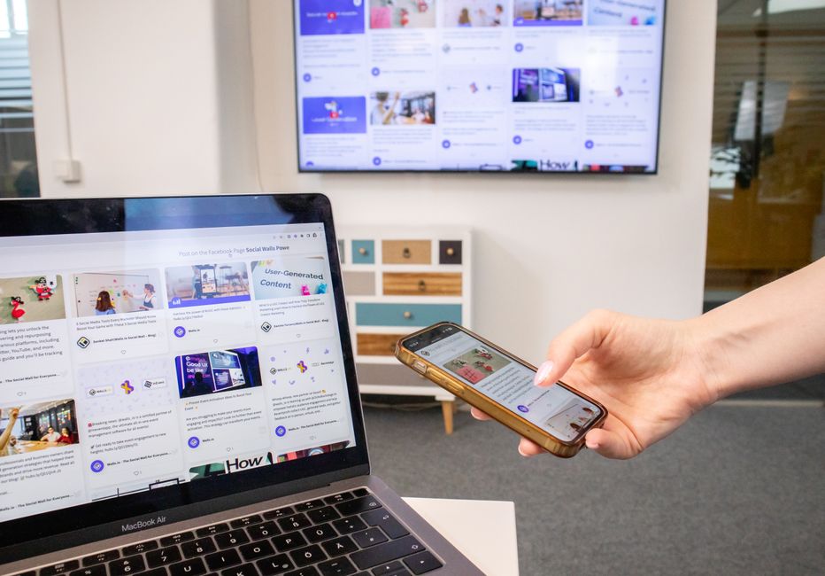 A small business owner in a casual office setting, using a laptop and tablet with AI tools to manage customer queries that combine voice, image, and text.