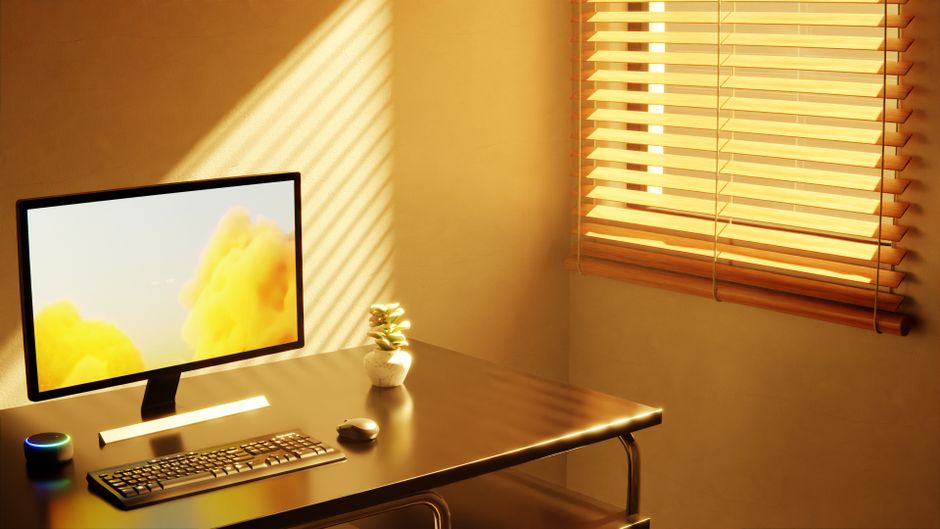 A well-organized small home office desk with a laptop, external monitor, and a comfortable keyboard, showing efficient use of space.