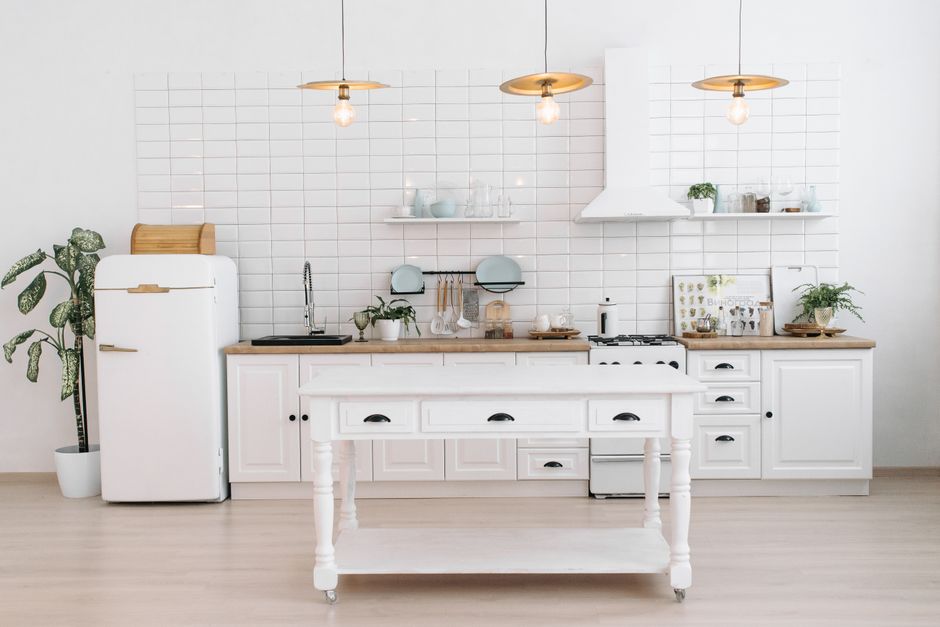 A compact kitchen counter with a rolling island serving as a temporary prep area, featuring a small cutting board and fresh vegetables.