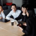 A small team of professionals in a modern office having a focused discussion around a table, symbolizing collaboration on AI policy.