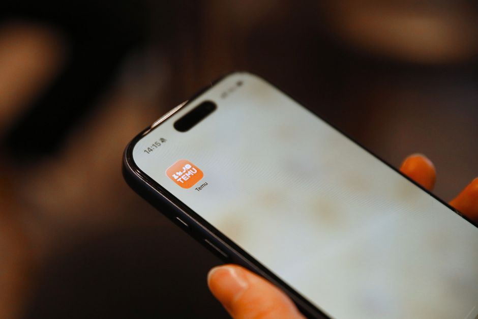 A close-up of a hand holding a smartphone with various delivery and ride-sharing app icons on the screen, reflecting convenience-driven spending.