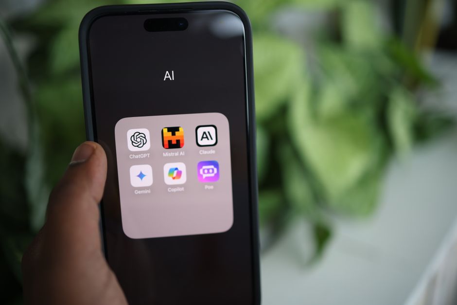Multiple hands from different people holding various AI Phones, each demonstrating a unique AI-powered feature like photo editing, language translation, or smart search.