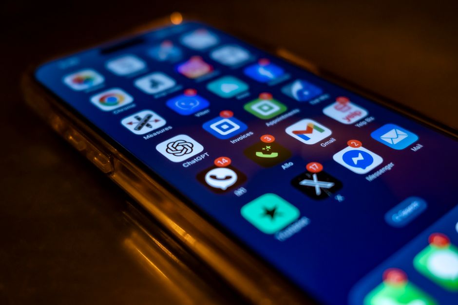 A smartphone screen cluttered with numerous unread messages and notifications from various group chats, showing the overwhelm of constant digital pings.