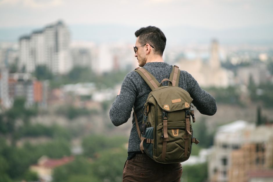 A solo traveler standing on a viewpoint overlooking Santiago, Chile, with the Andes mountains in the background, embodying a safe and inspiring journey.