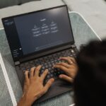 A solo founder looking at a laptop screen, which displays various AI tools and a dashboard, symbolizing efficient workflow management.