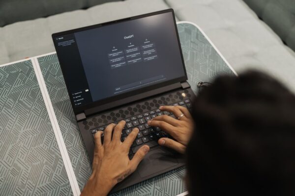 A solo founder looking at a laptop screen, which displays various AI tools and a dashboard, symbolizing efficient workflow management.