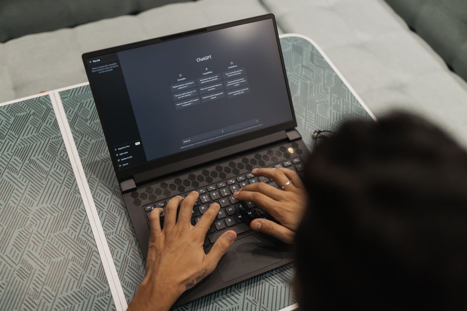 A solo founder looking at a laptop screen, which displays various AI tools and a dashboard, symbolizing efficient workflow management.