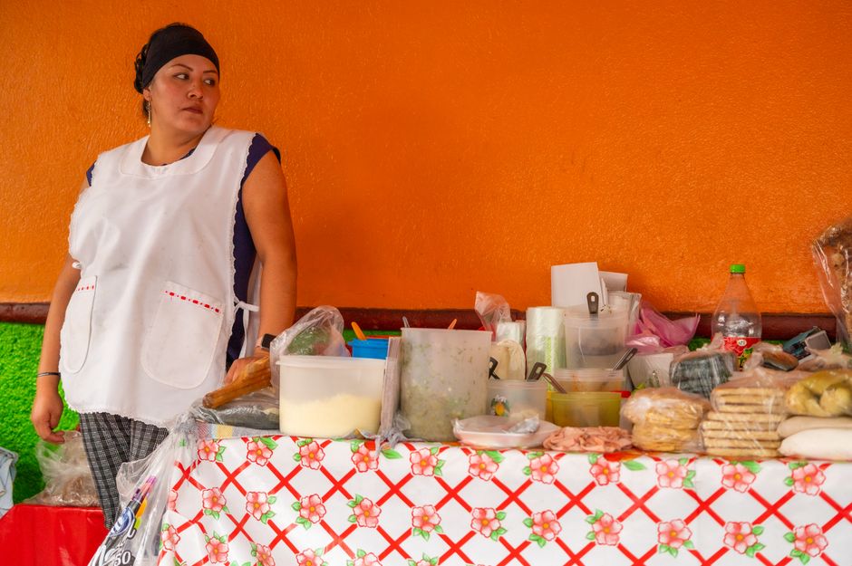 A vibrant street food market scene in Mexico City, with various stalls and people enjoying local cuisine.