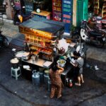 A bustling street food market with various stalls selling local delicacies and fresh produce, showcasing affordable culinary options.