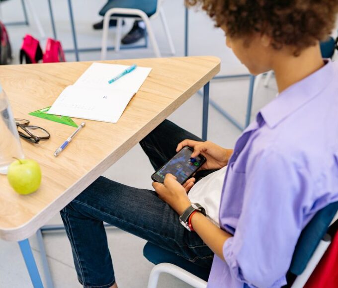 A student on a train happily playing a mobile game on their smartphone, looking relaxed and focused without any visible ad interruptions.