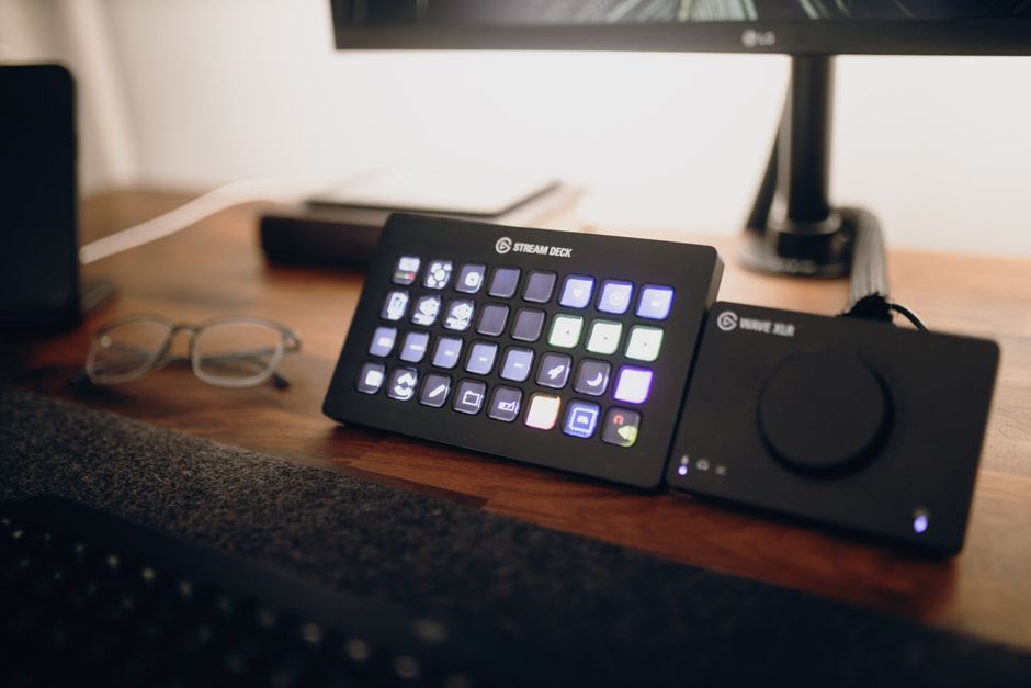 A student's desk with a laptop, a simple USB microphone, and a webcam, set up for budget game streaming.