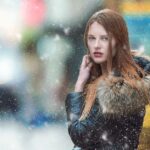 Stylish student walking in a snowy city street, showcasing smart winter layering outfits without a bulky coat.